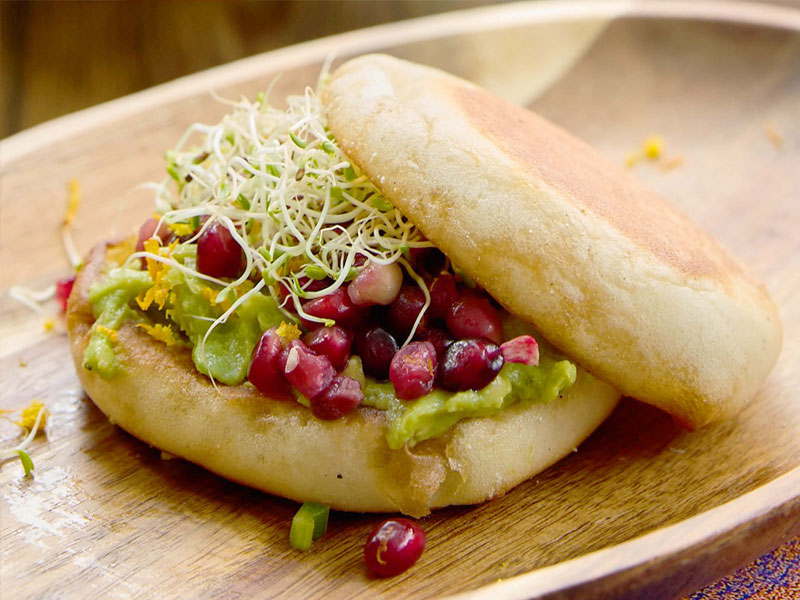 bays with green sauce, small purple fruit, sprouts and crumbly cheese