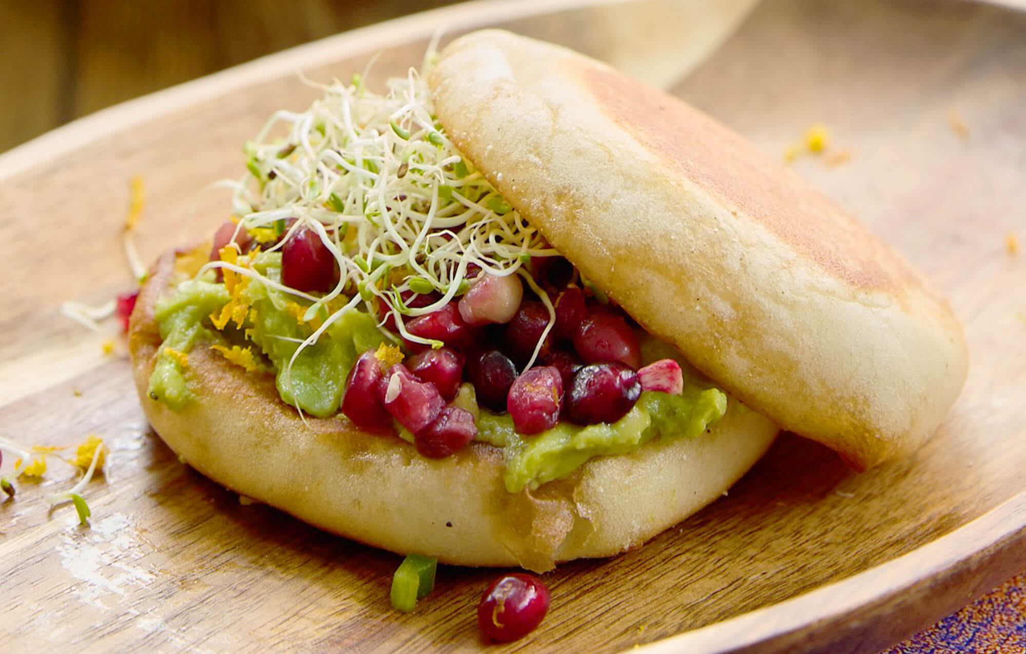 bays with green sauce, small purple fruit, sprouts and crumbly cheese