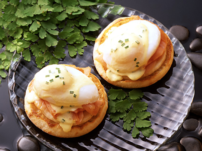 TWO BAYS TOPPED WITH COOKED FISH POACHED EGGS AND HOLLADAISE SAUCE