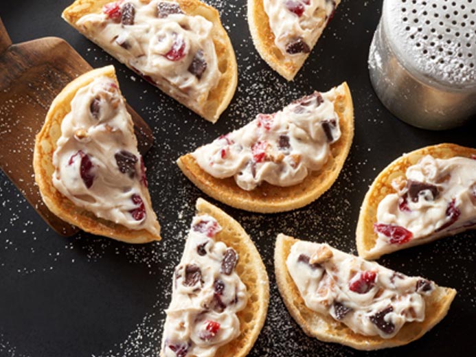English muffin halves topped with a white smear and brown chunks