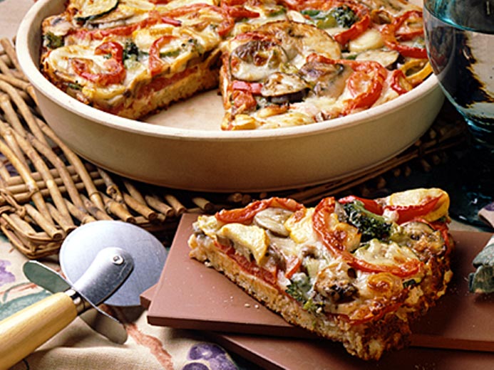 WEDGE OF BAYS TOPPED WITH A HEAP OF MELTED CHEESE AND COOKED VEGGIES