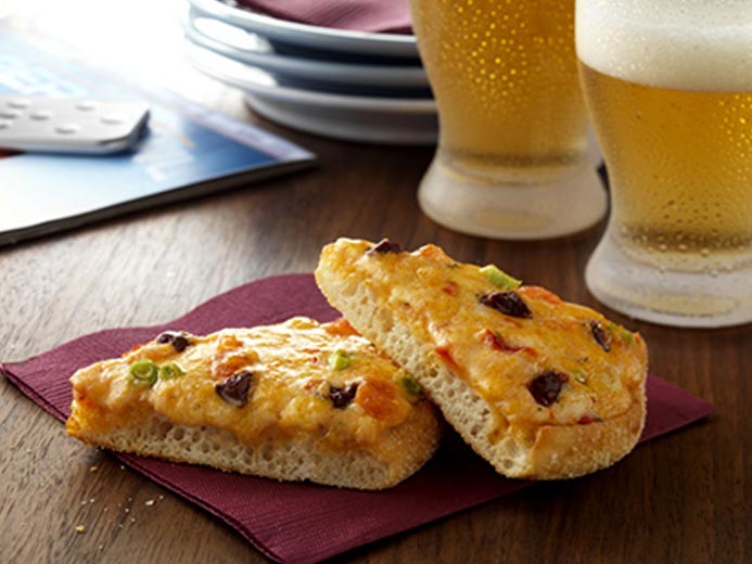 BEANS AND MELTED CHEESE ON BAYS WITH BEER IN THE BACKGROUND